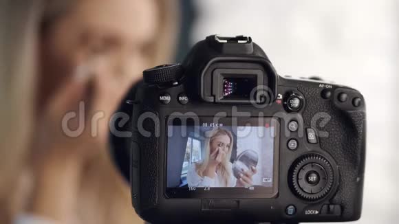 一个美容师正在用镜子把她的眉毛画在照相机上视频的预览图
