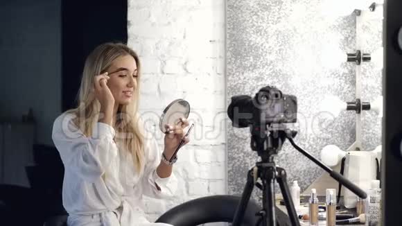 那个漂亮的金发化妆师正对着镜子刷眉毛视频的预览图