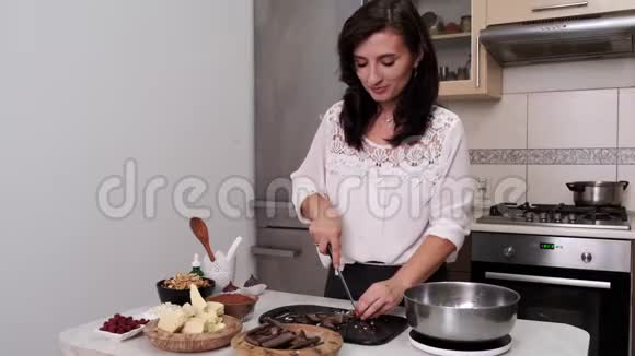 欧洲家庭主妇正在厨房里切黑巧克力视频的预览图