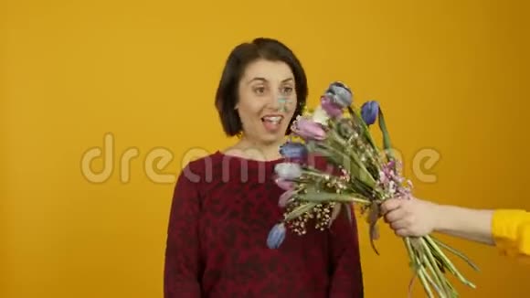 兴奋的成年女人接受鲜花和嘲笑相机视频的预览图