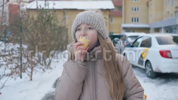 女孩在街上散步冬天吃冰淇淋视频的预览图