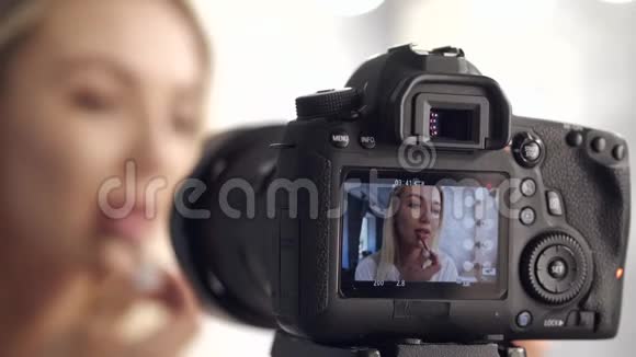 一位化妆师正在拍摄并在摄像机上展示视频的预览图