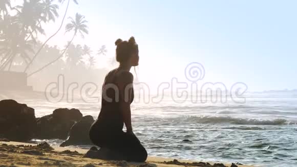 穿黑色运动服的运动女孩练习瑜伽姿势鸽子视频的预览图