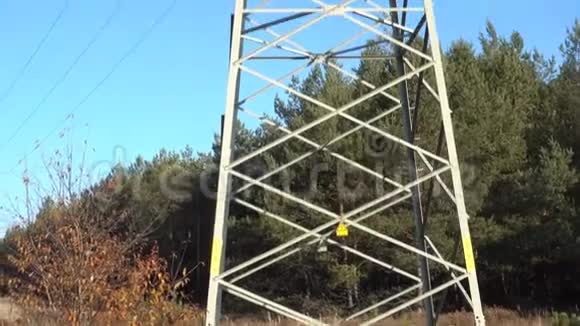 蓝色天空的森林里的电力塔架从底部到顶部的慢镜头视频的预览图