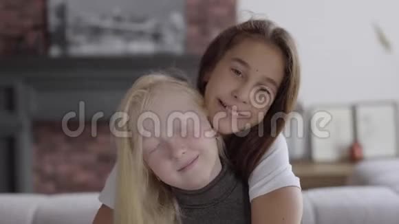 肖像可爱的小白化病女孩拥抱她的女朋友看着相机微笑友谊的概念免费视频的预览图