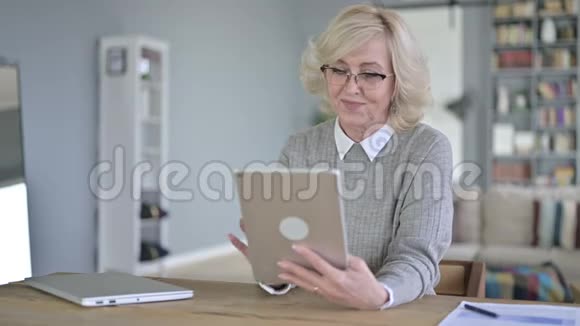 现代办公室使用平板电脑的老妇人视频的预览图