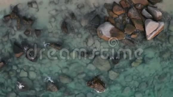 带绿松石海水和岩石的热带空海滩的俯视图视频的预览图