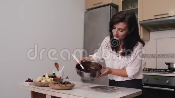 家庭主妇正在把热巧克力倒入烹饪形式视频的预览图