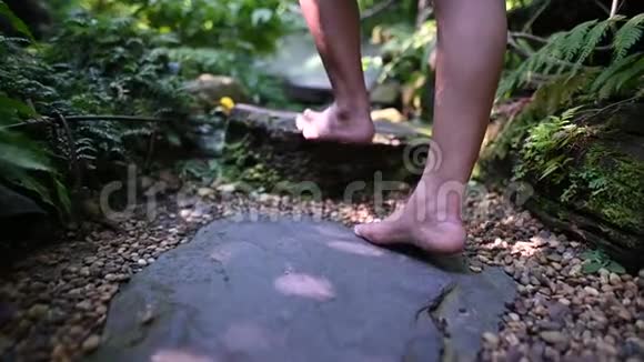 妇女在花园里散步的慢动作孤独的女孩脚没有鞋子在森林里视频的预览图
