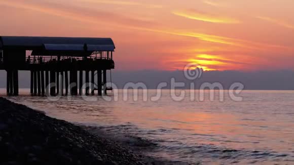 全景的夕阳越过海面旁边的码头剪影视频的预览图