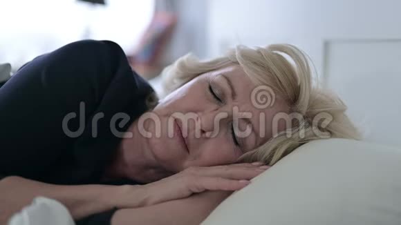 睡不着觉的老女人在床上头痛视频的预览图
