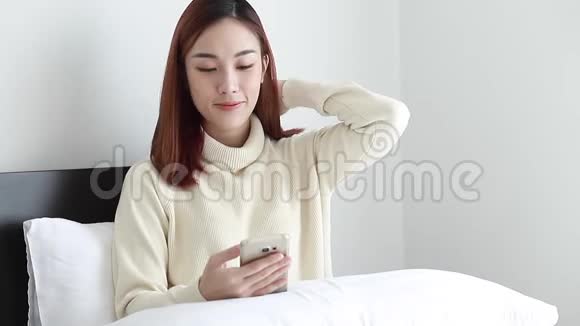 特写美女穿黄色毛衣用智能手机在家网上购物生活方式视频的预览图