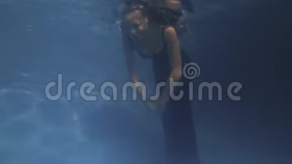 穿蓝色衣服的女人在水下游泳深蓝色的水4k视频的预览图