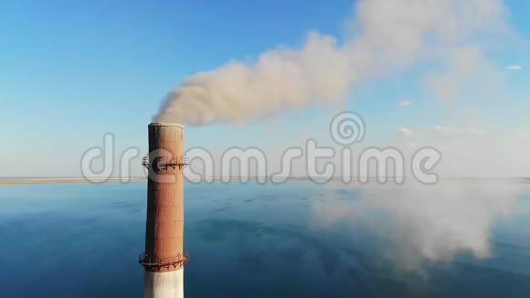 灰烟从工厂的一个大砖烟囱里冒出来顶着一片晴朗的蓝天和一个大湖视频的预览图