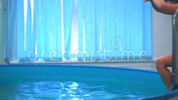 游泳池里的男孩带着泳镜跳进水里视频的预览图