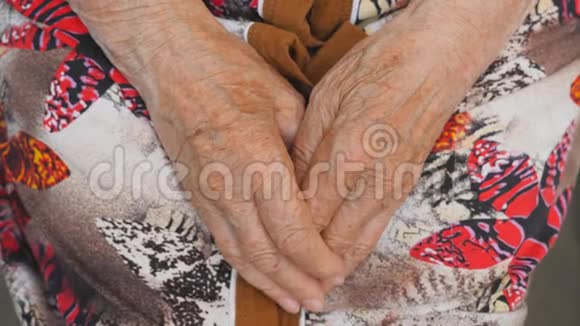 年轻的女性手臂用美丽的指甲安慰一双老女人的手孙女和祖母视频的预览图