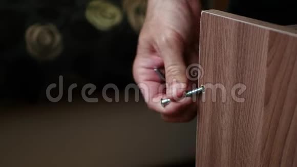 一个人手把螺丝钉拧成一块木头人工作视频的预览图