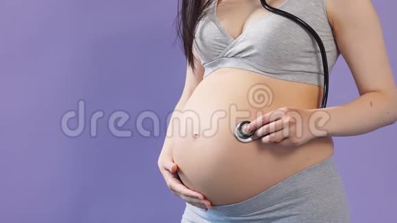 孕妇在家穿着用听诊器听肚子的衣服视频的预览图