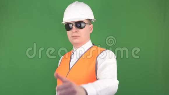 一个戴着黑色眼镜戴着白色防护头盔的男人在镜头前伸出大拇指一切都很好绿色视频的预览图