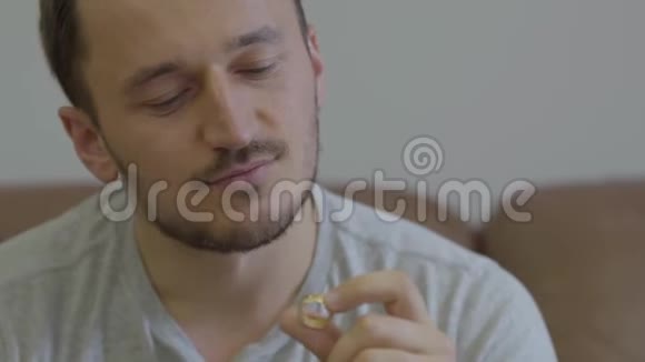 幸福的男人捧着金色结婚戒指的画像微笑着坐在家里他要提出一个建议视频的预览图