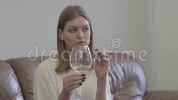 悲伤的女人拿着结婚戒指在酒杯下家庭问题背叛离婚分手的概念不安分的女孩视频的预览图
