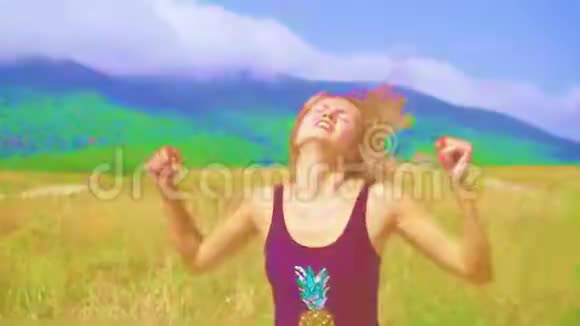 性感的女孩在山上的一条路上跳舞在一个阳光明媚的日子里有Hue的效果加速录像视频的预览图