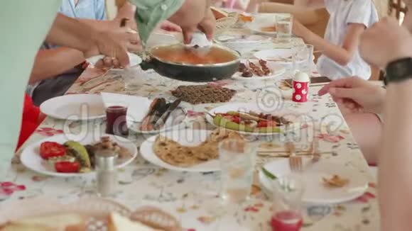 有自制食物的餐桌友好的家庭聚集在餐桌上为客人提供美味佳肴视频的预览图