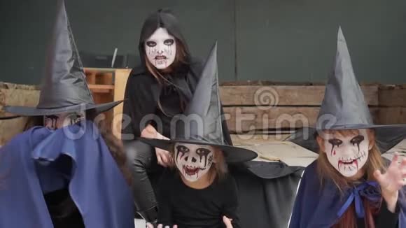 四个打扮成女巫僵尸骷髅和化妆的小女孩看着镜头有些吓人慢动作视频的预览图