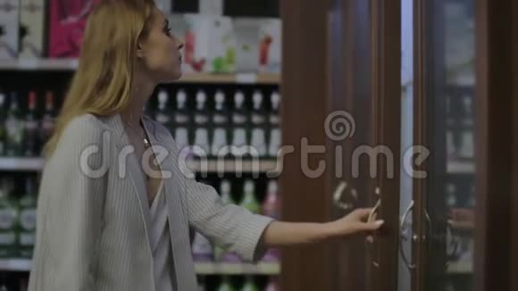 女士在超市选择葡萄酒顾客在商店的货架上选择产品卖酒精读一读视频的预览图