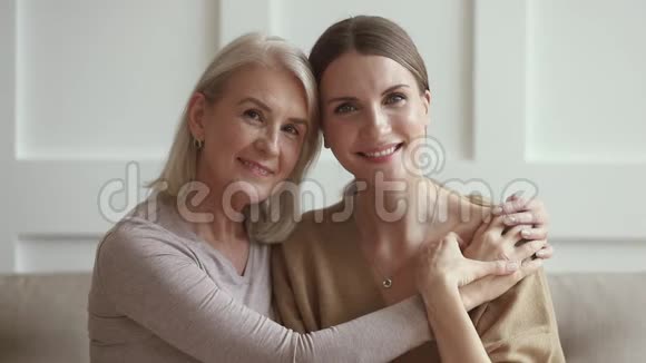 微笑成熟的爱心妈妈抱着年幼的成年女儿画像视频的预览图