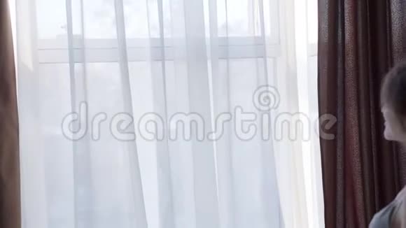 女孩靠近窗户微笑着亲吻男友视频的预览图