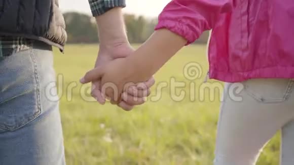 一只成年男性手的特写握着年轻女孩手掌白种人的父女团结视频的预览图