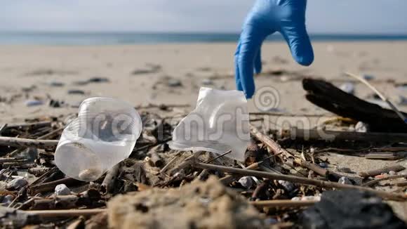 人在海边捡拾塑料玻璃垃圾清理生态系统污染视频的预览图