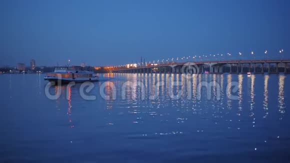 船在照明桥的背景下向码头靠近河流视频的预览图
