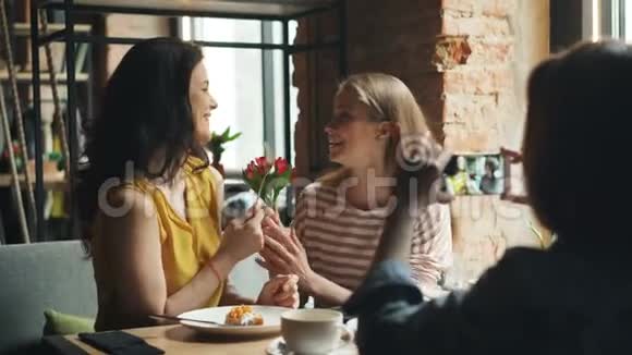 提供免费的女性在咖啡馆里摆着智能手机摄像头尽情享受视频的预览图