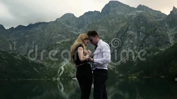 一个穿着服装的男人向他心爱的女人求婚在一个湖边戴上订婚戒指视频的预览图