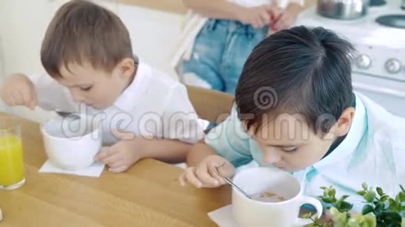 两个小男孩在厨房吃月饼做早餐视频的预览图