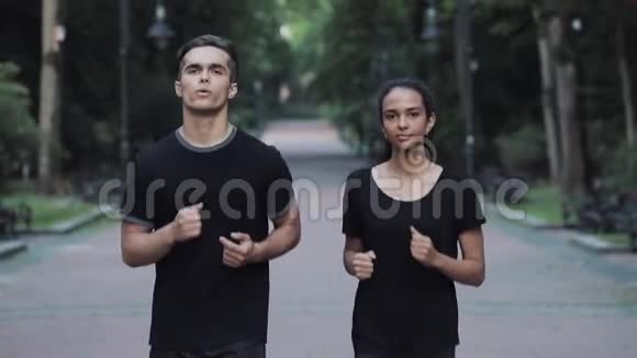 年轻人和女孩在公园里跑步男人变得疲倦停止女孩继续跑步的概念健康的生活方式视频的预览图