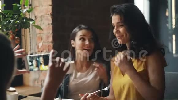 美女们在咖啡厅喝咖啡用智能手机笑着拍照视频的预览图