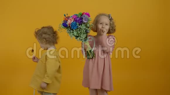 带着鲜花拥抱和吃棒棒糖的快乐孩子视频的预览图