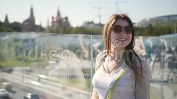 一个女孩站在城市里河上的一座桥上视频的预览图