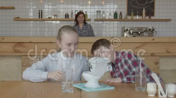 快乐的孩子们笑着玩自助餐厅桌上的玩具视频的预览图
