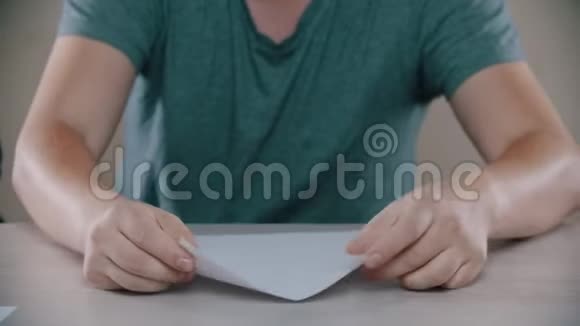 男人在桌子上折叠一架纸飞机视频的预览图