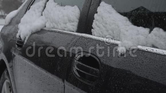 冬天下雪时雪落在汽车的侧窗上交通恶劣的天气条件暴风雪视频的预览图
