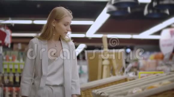 有魅力的女孩顾客在面包店买面包闻着面包微笑着购物视频的预览图