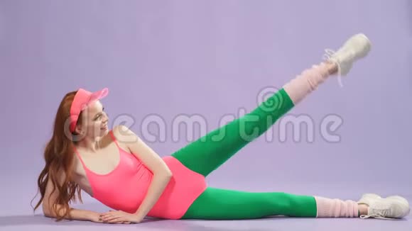健康活泼的姜姑娘穿着五颜六色的健美操服做运动视频的预览图