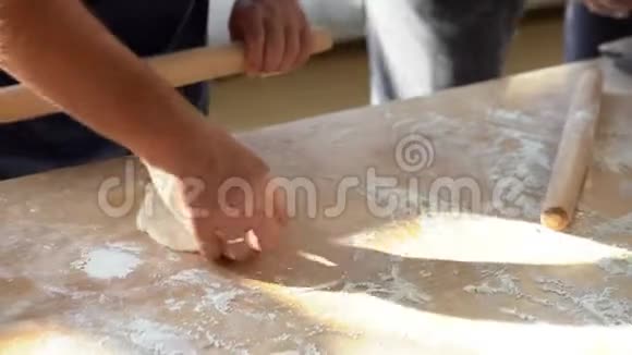 面包师厨师手准备新鲜面团与擀面杖在厨房的餐桌上餐厅面包店的菜肴视频的预览图