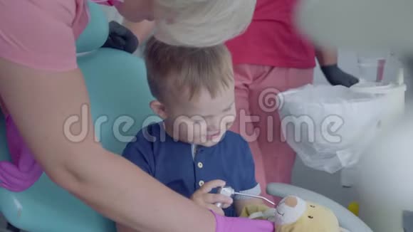 可爱的小孩子玩医疗工具坐在牙医办公室的椅子上免费儿童出诊医生视频的预览图