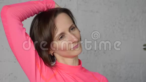年轻女子伸展颈部肌肉同时按摩自己女人做运动放松颈部肌肉保健视频的预览图