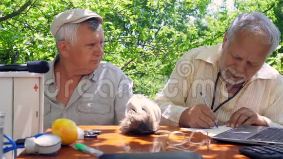 老人用手与同事和宠物刺猬交谈视频的预览图